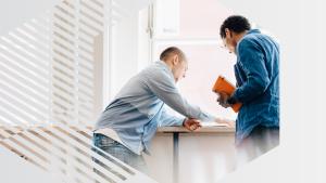 Photo of two people collaborating, viewed through a hexagon