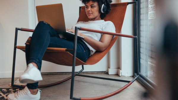 A developer sits in a rocking chair, with a computer