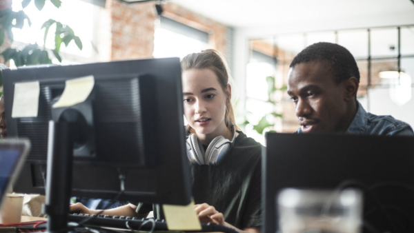 Two developers work together at a computer