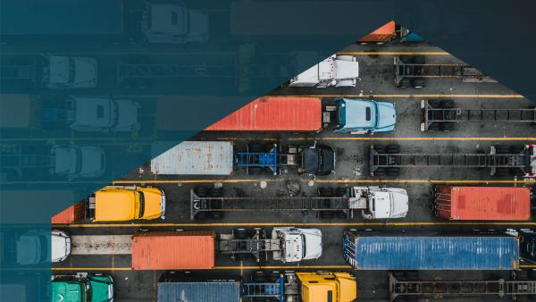 Photo of trucks and trailers with multiple colors of shipping containers, viewed from above, viewed through a hexagon