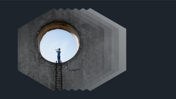 Person looking through a telescope, standing in the round opening of a concrete structure, in front of a blue sky