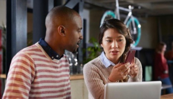 People gathering around computer and talking